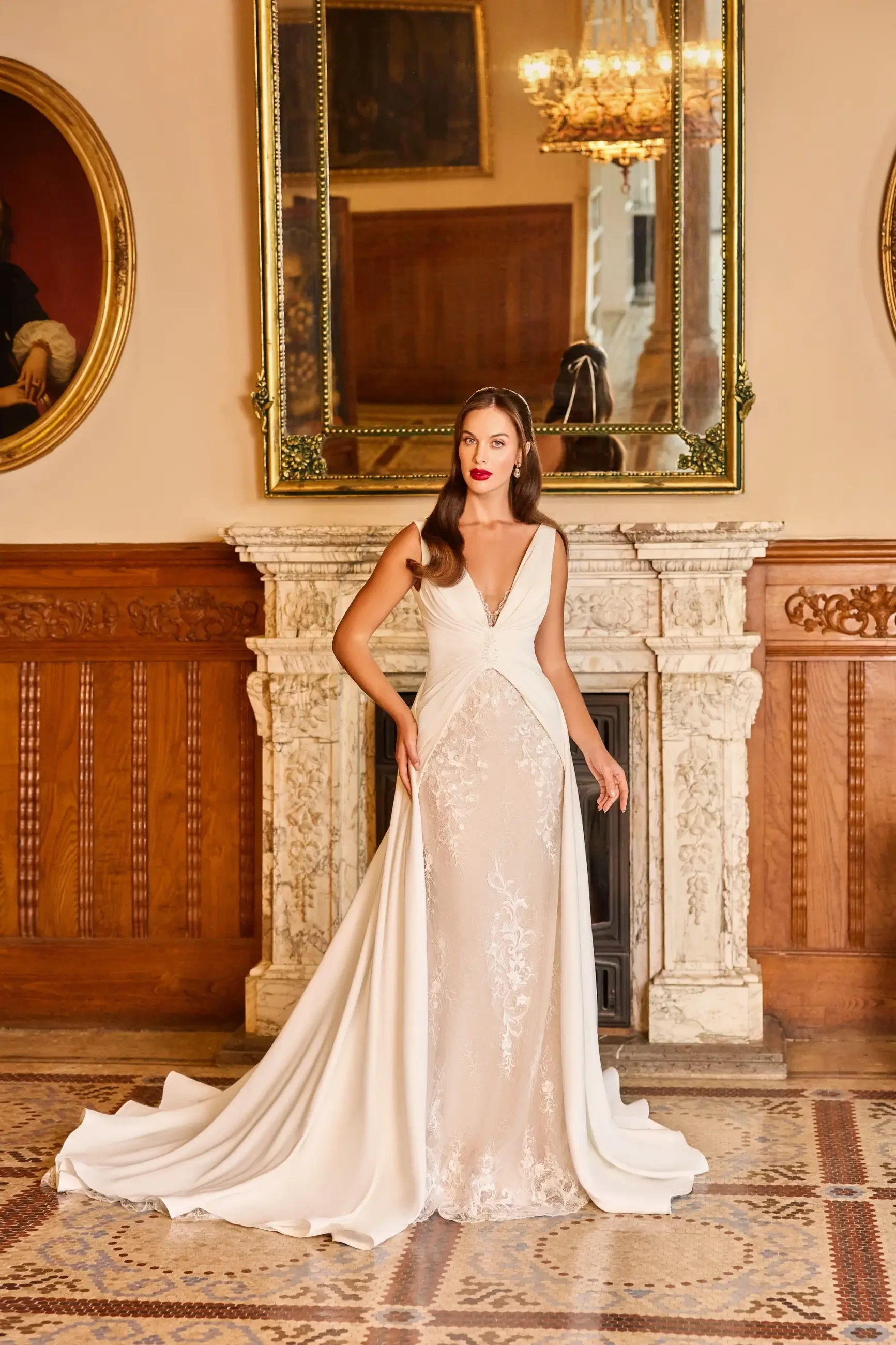 A woman in a stylish white dress stands elegantly in a grand room with ornate decor.