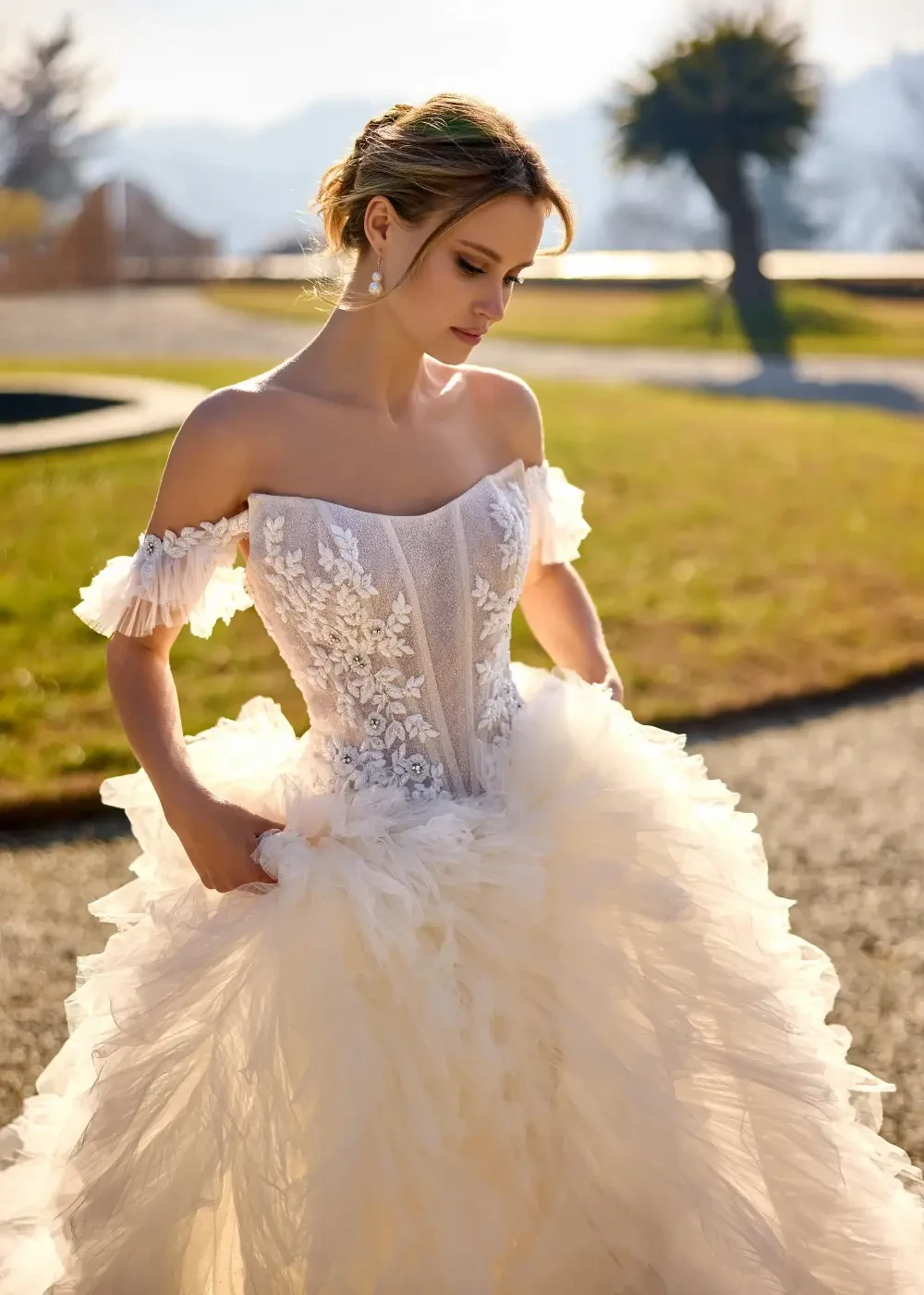 model is wearing an off the shoulder bridal gown